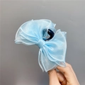 Detailansicht einer Haarklammer mit hellblauer Organza-Schleife in der Hand - Himmelblaue Haarklammer
