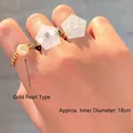 Detailweergave van een bohemian ringenset met gouden en zwarte kralen om de hand - Gouden Parelring