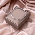 Detail of silver minimalist knot cuff bracelet on champagne silk and jewelry box surface - Silver Adjustable Style