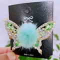 Detail of a gold butterfly hair clip with green crystals and soft pompom embellishments - Moving Butterfly Fuzzy Ball Style / Matcha Green