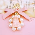 Detail of pink fabric bow keychain with white faux pearls and elegant fringe tassel - Pink