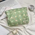 Detailed top view of a green floral cosmetic bag with laptop and toiletries - Green Lotus Floral