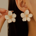 Elegante weiße Blumenohrstecker mit Goldrand, getragen von einem weiblichen Model - KC Gold Weiß (11765)