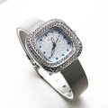 Detail of silver square watch with crystal bezel and metal mesh band on white background - Blue Diamond Dial