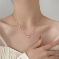 Macro detail of a pink heart pendant on a gold pearl necklace worn on the collarbone - Light KC Gold Pearl Heart (1682)