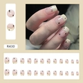 Dettaglio macro di unghie finte corte riutilizzabili con stelle nere su base beige - Stelle Brillanti (R430)