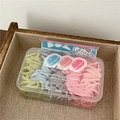Pastel color hair elastics in a cartoon box featuring yellow, blue, grey and pink bands - Burger Style