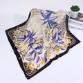 Detailansicht eines Seidenschals mit blauen Blattmustern und schwarzem Rand auf Weiß - Blau / 70*70 Cm