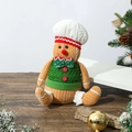 Close-up of a knitted gingerbread man chef candy jar on a festive wooden surface - Sitting Gingerbread Man Doll Chef Hat