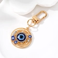Detailed close-up of golden Evil Eye keychain with blue crystals and sparkling rhinestones - Gold Hollow Round Eye