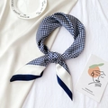 Vue détaillée du foulard en soie à carreaux pied-de-poule bleu et blanc noué sur plat - 70x70cm / Bleu