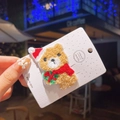 Détail d'une pince à cheveux ours de Noël en peluche brodée sur carte de présentation - Ours Gris en Tissu Éponge