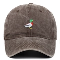 Close-up of duck embroidery and vintage washed fabric texture on brown baseball cap - Coffee