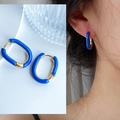 Dettaglio di orecchini a U dorati con smalto blu e vista ravvicinata sull'orecchio - Blu Klein