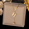 Detail of gold titanium steel H-letter pendant necklace with square charm on jewelry box - Letter H-Gold