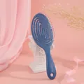 Detail der blauen Haarbürste mit flexiblem Spiraldesign und Massageborsten für das Haar - Dunkelblau