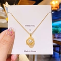 Collier élégant en acier titane doré avec pendentif perle et zircon sur carte blanche - Perle Camélia Dorée