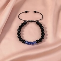 Close-up of adjustable beaded bracelet with blue floral glass beads on pink silk - Obsidian Luminous Royal Blue