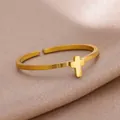 Close-up of golden stainless steel open ring featuring a minimalist cross design on silk - Gold Cross