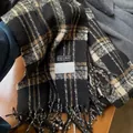 Détail de l'écharpe épaisse à carreaux avec franges à pompons et étiquettes tissées - Noir