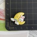 Macro shot of resin rabbit on moon accessory with rainbow detail on measurement ruler - Yellow Moon Rainbow Rabbit
