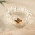 Close-up of white crystal beaded bracelet featuring a golden clover charm on a beige stand - White Crystal Clover (Includes Exquisite Gift Box) / 10mm Bead Diameter