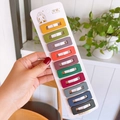 Close-up of ten colorful matte snap hair clips neatly displayed on a white paper card - Dark Colors (Hollow Square Style)