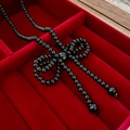 Macro detail of black beaded necklace with a vintage bow pendant in a red velvet box - Small Black Imitation Pearl Bow Necklace