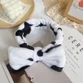 Soft plush headband featuring classic black and white cow spots and a large bow design - Cow Pattern