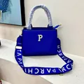 Detail of Klein blue tote bag featuring golden letter P hardware and printed strap - Blue