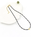 Chic beaded necklace with black faceted beads and a golden heart pendant on a white tray - Black
