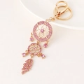 Portachiavi acchiappasogni con cristalli rosa e placcatura oro su sfondo bianco - Rosa
