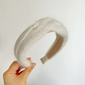 Close-up of white plush knitted headband with soft fuzzy texture and knotted design - Braided / Beige