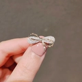 Élégante broche nœud dorée avec cristaux étincelants tenue dans la main - Style Nœud Papillon (0234)