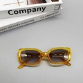 Detail view of retro amber oval sunglasses with gradient lenses resting on a stack of books - Transparent Yellow