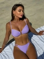 Close-up of lavender bikini with wavy texture and gold metal buckle on beach towel - Violet