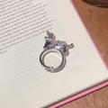 Détail macro de la bague chiot argentée avec zircons et perle sur une page de livre - Style ouvert réglable / Argent Chiot