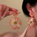 Detailed view of large coral pink raffia flower earrings with golden center on model - 18# Silver Needle-Gold-Deep Pink (Large Flower)