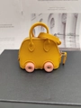 Mini car-shaped keychain bag in bright yellow with pink wheels and top handles - Yellow