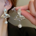 Elegant Chinese fan-shaped silver earrings with pearls worn by a model for a classic look - Hollow Fan Pearl Style (36#)