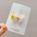 Detailed close-up of double-layered orange tulle butterfly hair clip with rhinestones - Orange
