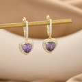 Dettaglio macro di orecchini a cuore dorati con zircone viola e micro cristalli pavé - Oro Viola