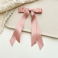 Detail view of pink satin double bow hairclip with long ribbons on a lace background - Deep Pink