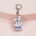 Cute white cartoon dog acrylic keychain with blue striped shorts on pink display stand - Dog Waving