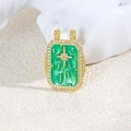 Macro shot of a vintage gold pendant featuring green stone and sparkling star pattern - Green Star Zirconia Style (ZYN-DMK872G-1)
