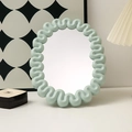Light blue oval makeup mirror with wavy frame on desk in cream style setting - Round Light Green
