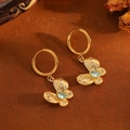 Detail von goldener Schmetterlings-Creole mit grünem Tropfenstein und Kristallbesatz - Gold Schmetterling Blau Zirkonia Ohrringe (T031)