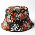 Dettaglio della stampa a foglie di palma tropicale su un cappello a secchiello nero - M (56-58cm) / Stile A (Nero con foglie arancioni e bianche)