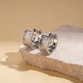 Macro shot of silver textured hoop earrings with irregular ripples on porous stone - Silver (18K Gold Plated)