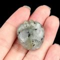 Natural gray labradorite stone pendant with unique gear-shaped carving in hand - Labradorite